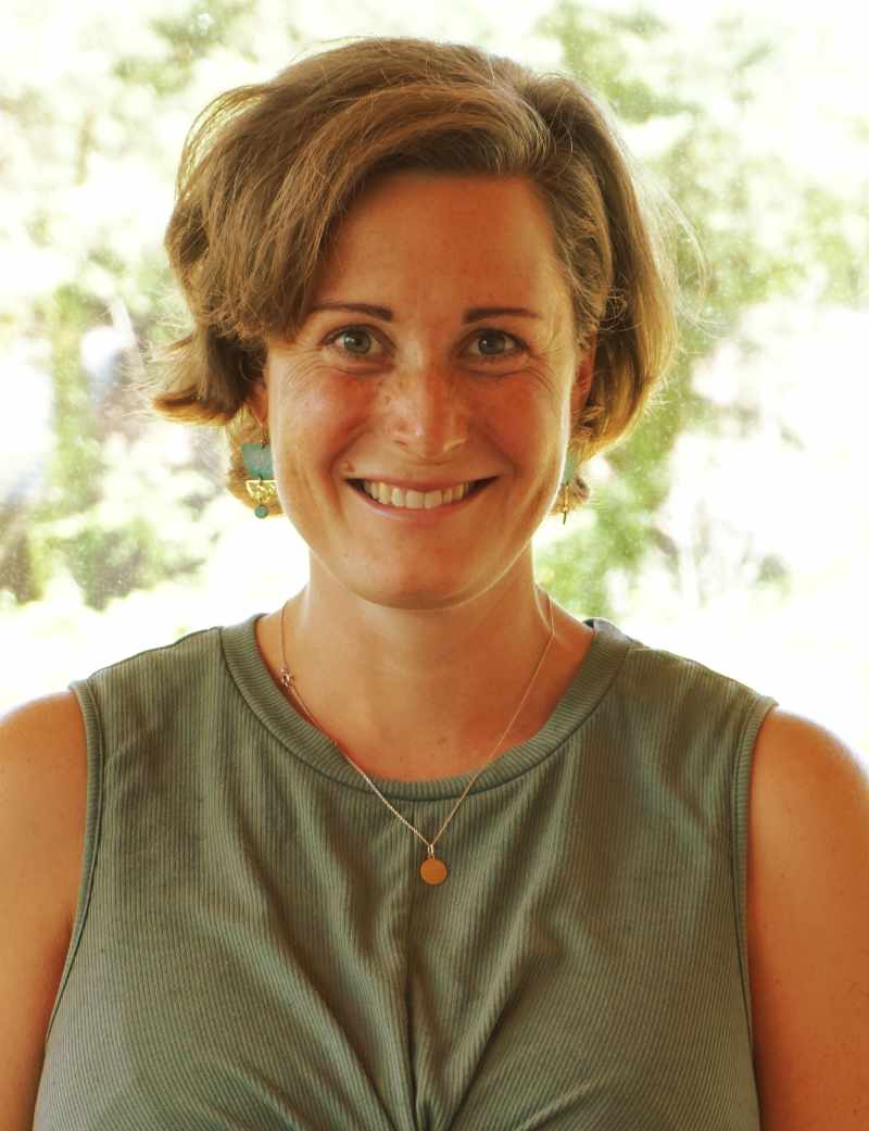 Nadine Sommer, lächelnd vor sommerlichem Grün